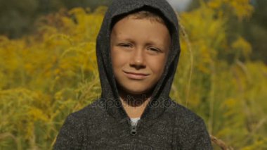 Yakışıklı bir gri süveterli açık havada bir kukuleta ile