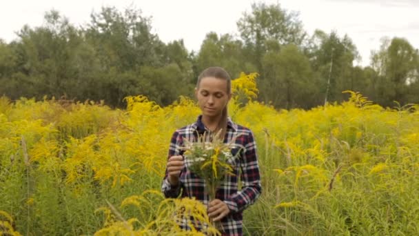 Дівчина з букетом з польових квітів в руках — стокове відео