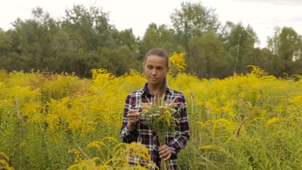 Meisje met boeket van wilde bloemen in handen — Stockvideo