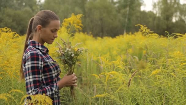 Girl with bouquet of wildflowers in hands — Stock Video