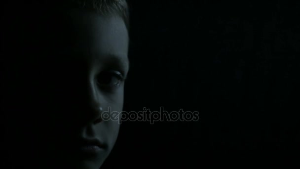Rapaz triste close-up: meia cara no escuro — Vídeo de Stock
