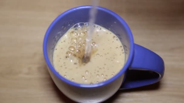 Cappuccino fresco com espuma em um copo azul — Vídeo de Stock