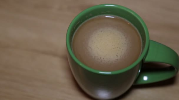 Cappuccino quente com espuma em uma xícara verde — Vídeo de Stock