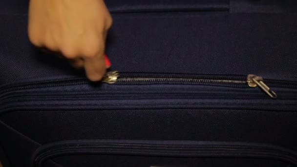 The hand pulls the zipper on the luggage — Stock Video
