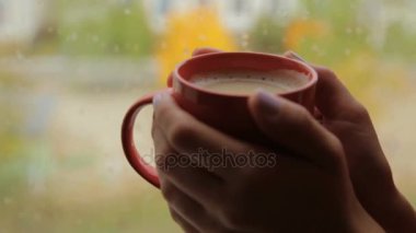 Kupa kapuçino pencerenin yakınındaki eller