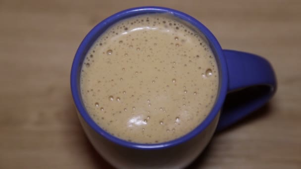 Cappuccino fresco con espuma en una taza azul — Vídeos de Stock