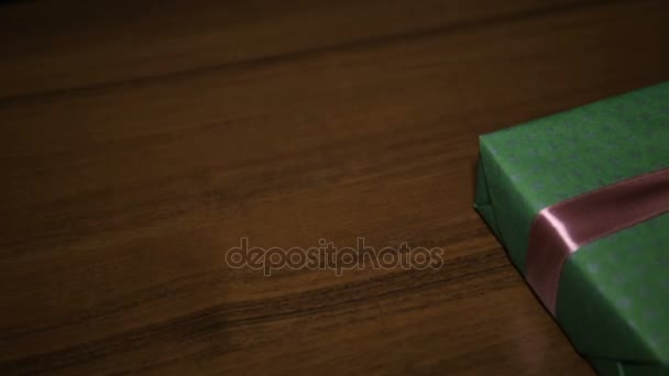 Cadeau de Noël dans une boîte attachée avec un ruban brun avec un arc — Video