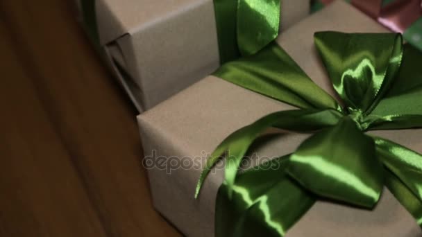 Regalo di Natale in una scatola legata con un nastro verde con un fiocco — Video Stock