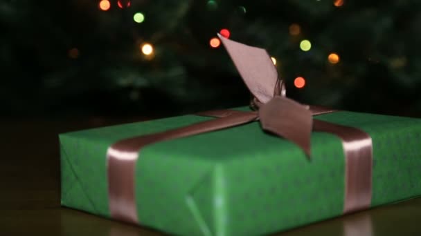 Regalo de Navidad en una caja atada con una cinta marrón con un lazo — Vídeos de Stock