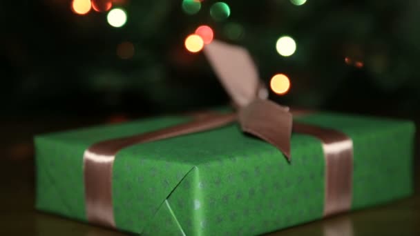 Regalo de Navidad en una caja atada con una cinta marrón con un lazo — Vídeos de Stock