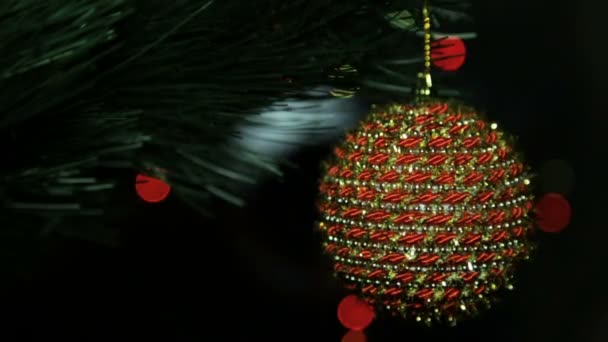 Juguete de Navidad en un árbol de Navidad contra una guirnalda en el desenfoque — Vídeos de Stock