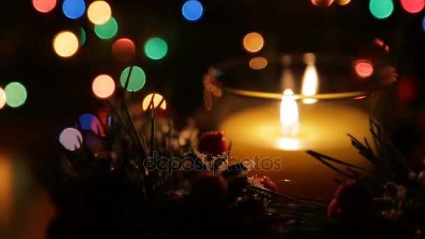 Una vela encendida en una noche de Navidad contra el telón de fondo de un bokeh — Vídeos de Stock