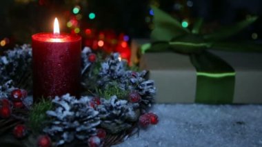 Bir mum ve bir bokeh arka planda bir hediye kutusu