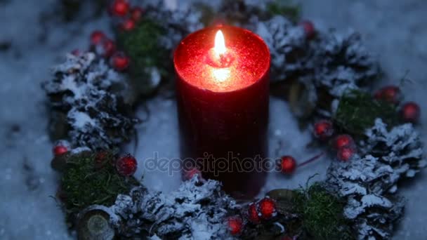 Una vela encendida en la noche de Navidad sobre el fondo de la nieve artificial — Vídeo de stock