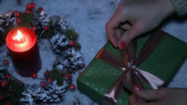 Una mujer está atando un lazo en un regalo de Navidad — Vídeos de Stock