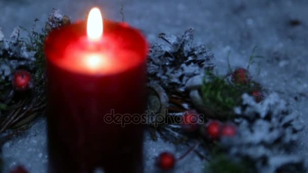 Uma vela acesa na noite de Natal contra o fundo da neve artificial — Vídeo de Stock