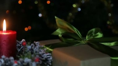 Bir mum ve bir bokeh arka planda bir hediye kutusu