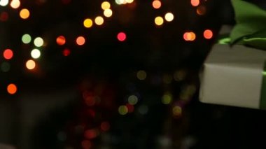 Bir kadın bir çocuk için bir yeni yıl hediye verir. Onu bir kutuya bir bokeh arka plan üzerinde eller