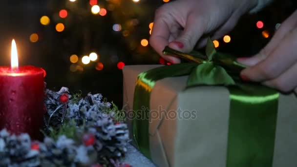 Eine Frau bindet eine Schleife an ein Weihnachtsgeschenk — Stockvideo