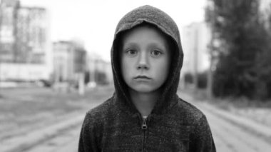 Sokakta siyah başlıklı bir çocuk.