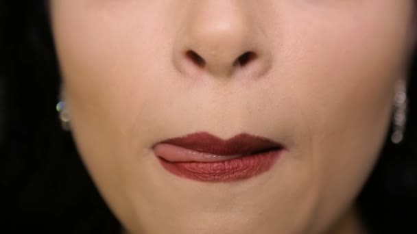 Vrouw likt zijn lippen met rode lippenstift — Stockvideo