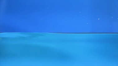 Çerçeveyi dolduran su sıçramalarına. Mavi arka plan.