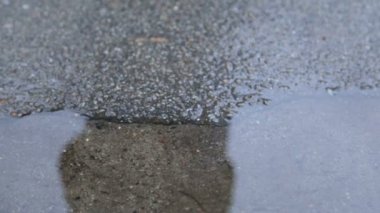 Bir çocuğun bir su birikintisi içinde bacaklar