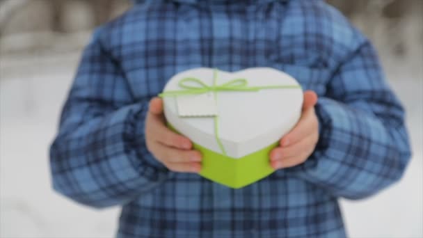 Caja de regalo en forma de corazón en las manos de un niño — Vídeo de stock