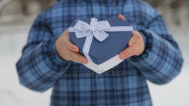 Caja de regalo en forma de corazón en las manos de un niño — Vídeo de stock