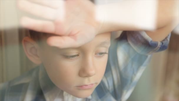 Λυπημένο Παιδί Κοιτάζει Έξω Από Παράθυρο — Αρχείο Βίντεο