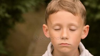 Genç çocuk gülümsüyor ve kameraya poz veriyor.