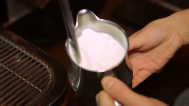 Бариста взбивает молоко в банке на профессиональной кофеварке — стоковое видео