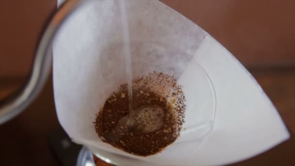 Barista verse de l'eau à travers le filtre dans la fiole pour faire le café infusé 