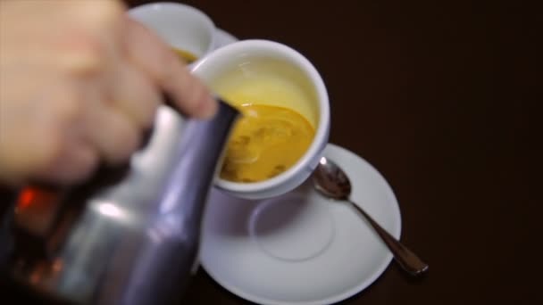 Barista verse du lait frais dans le café. Cappuccino .