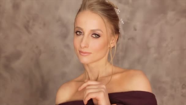 Porträtt av en modell med en vinröd halsduk på en grå bakgrund — Stockvideo