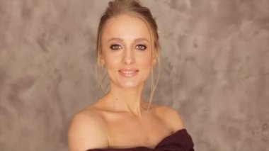 Bir model gri bir arka plan üzerinde bir bordo eşarp ile portresi