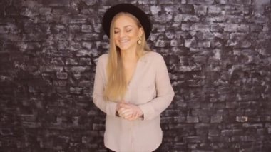 Siyah bir şapka ve bir tuğla duvar arka planda poz bir gri gömlek modeli