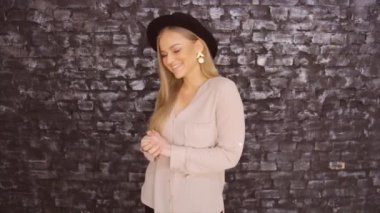 Siyah bir şapka ve bir tuğla duvar arka planda poz bir gri gömlek modeli
