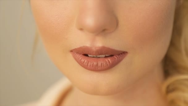 Blond meisje bijt haar lip en glimlacht — Stockvideo