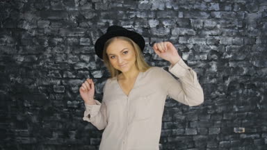 Dokulu duvar arka plan üzerinde siyah şapkalı bir kız dans ediyor