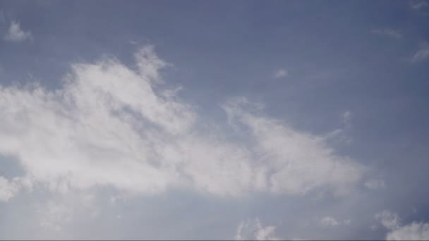 Vackra vita moln svävar över skärmen i tid förfaller mode över en djupblå bakgrund. — Stockvideo
