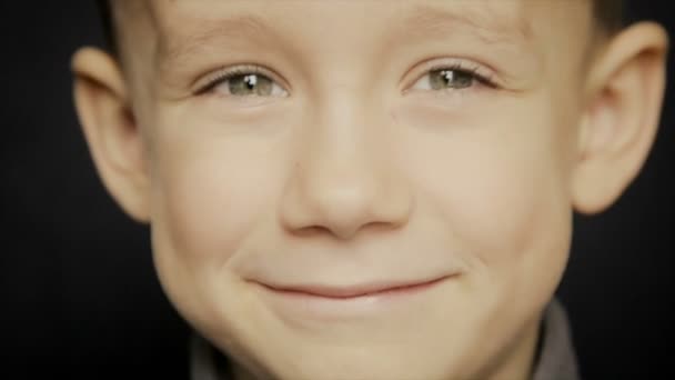 Portrét chlapce close-up na černém pozadí — Stock video