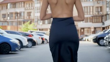 Otoparkta poz şık bir siyah elbise ince kız. Kamera kablolama aşağıdan yukarıya