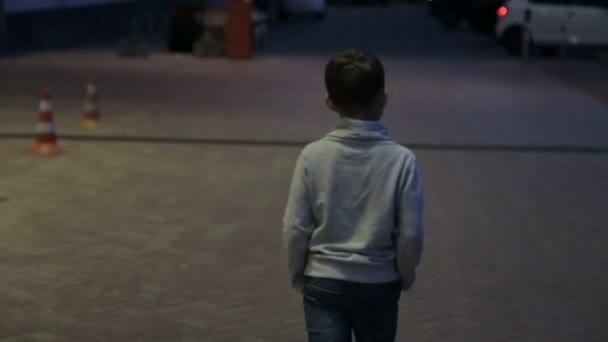 L'enfant marche à travers la ville de nuit — Video