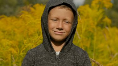 Yakışıklı bir gri süveterli açık havada bir kukuleta ile