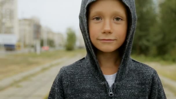 Мальчик в черном капюшоне на улице — стоковое видео