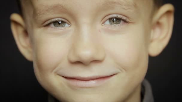 Porträtt av en pojke närbild på en svart bakgrund — Stockvideo