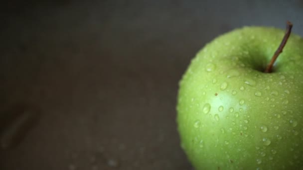 Rotation eines grünen Apfels mit Wassertropfen — Stockvideo