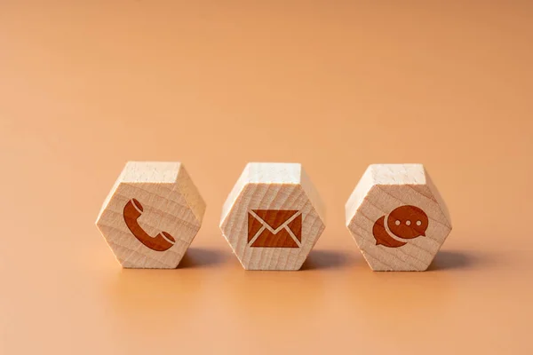 Contact us icon on wood puzzle with hand — Stock Photo, Image