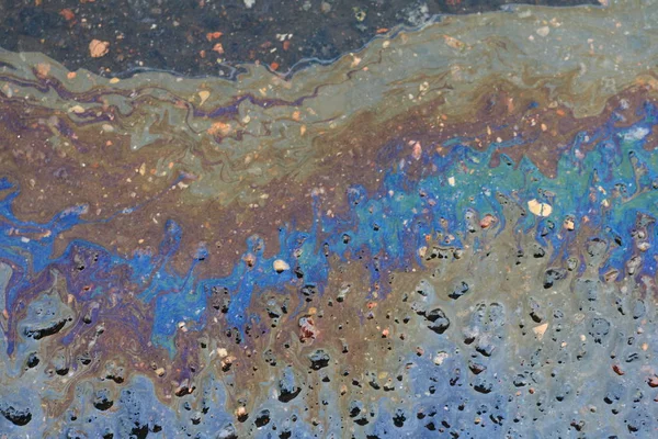 アスファルトの道路にガソリンから大きな多色斑点 — ストック写真